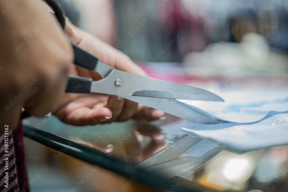 a fashion designer cutting her cloth to make a dress a fashion designer cutting her cloth to make a dress