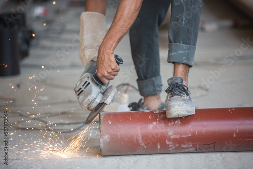 a lauber sanding a pipe by a sander photo