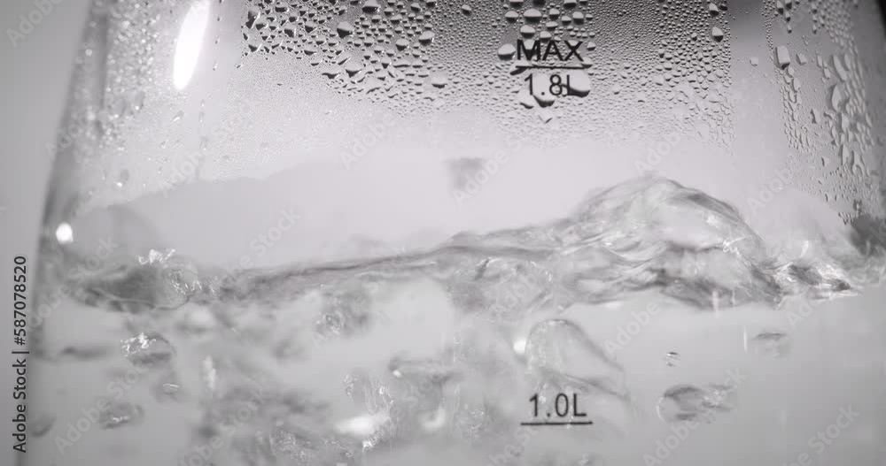 Background, bubbles of hot water in a transparent electric kettle. Close up view of boiling water boiling water in a transparent dish or in a glass teapot or saucepan, boiling water strong bubbling Background, bubbles of hot water in a transparent electric kettle. Close up view of boiling water boiling water in a transparent dish or in a glass teapot or saucepan, boiling water strong bubbling