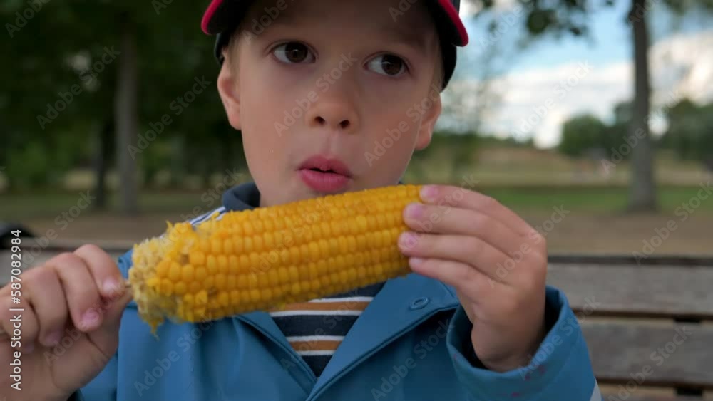 The boy eating boiled corn with appetite. 4k close up video footage The boy eating boiled corn with appetite. 4k close up video footage