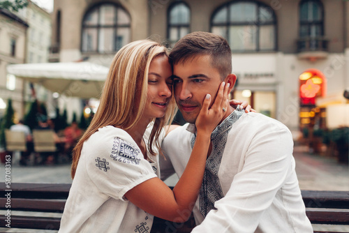 Loving couple relaxing in old Lviv city wearing traditional national ukrainian shirts. Newlyweds spend time together