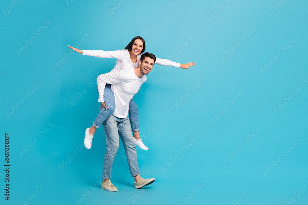Full size photo of two excited crazy partners hold piggyback arms wings empty space isolated on blue color background