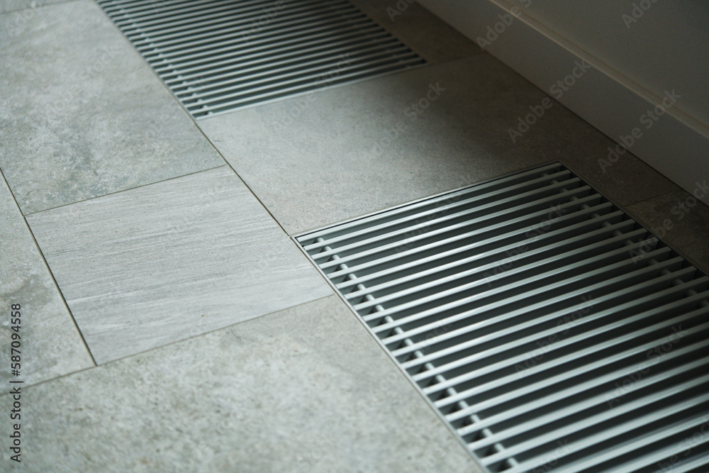 Naklejka premium Heating grill with ventilation in the floor in laminate.. Forced hot-air heating systems are extremely popular and feature vents like this to channel the hot air throughout the house.
