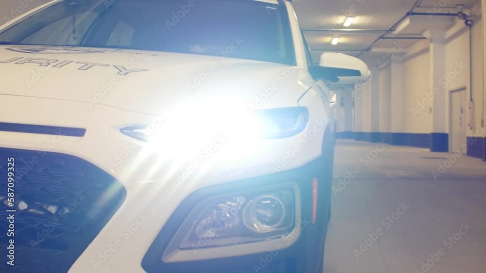 Head light of a security patrol car inside a parking lot in a residential area. Head light of a security patrol car inside a parking lot in a residential area.