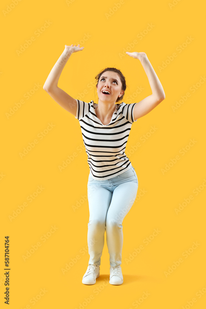 Scared young woman on yellow background Scared young woman on yellow background