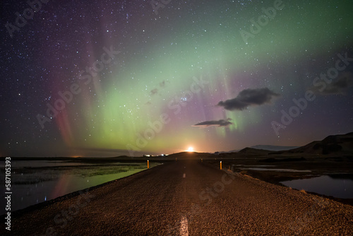 Aurora borealis over road and moon, road trip Iceland