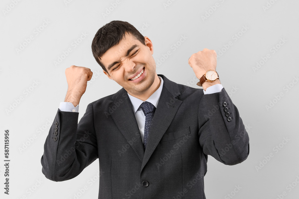 Happy young businessman on light background Happy young businessman on light background