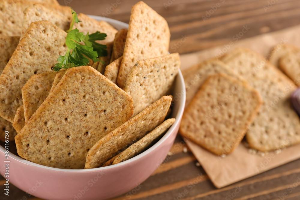 Bowl with tasty crackers and parsley on wooden background Bowl with tasty crackers and parsley on wooden background
