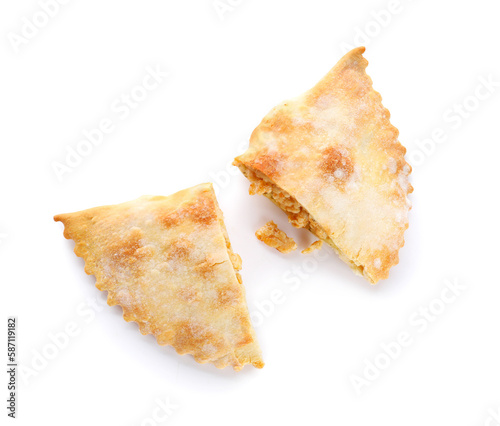 Halves of baked meat empanada on white background