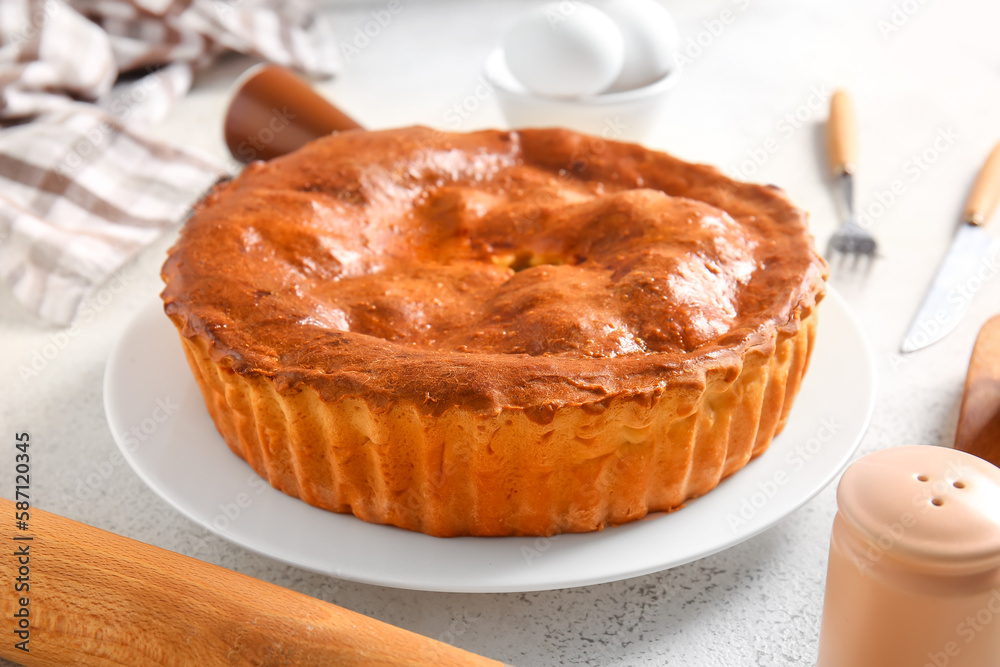 Plate with delicious meat pie on white grunge table Plate with delicious meat pie on white grunge table