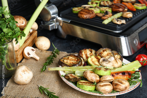 Plate with tasty grilled vegetables on table