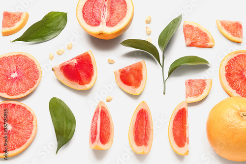 Fototapeta Naklejka Na Ścianę i Meble -  Composition with pieces of ripe grapefruit, seeds and plant leaves on white background