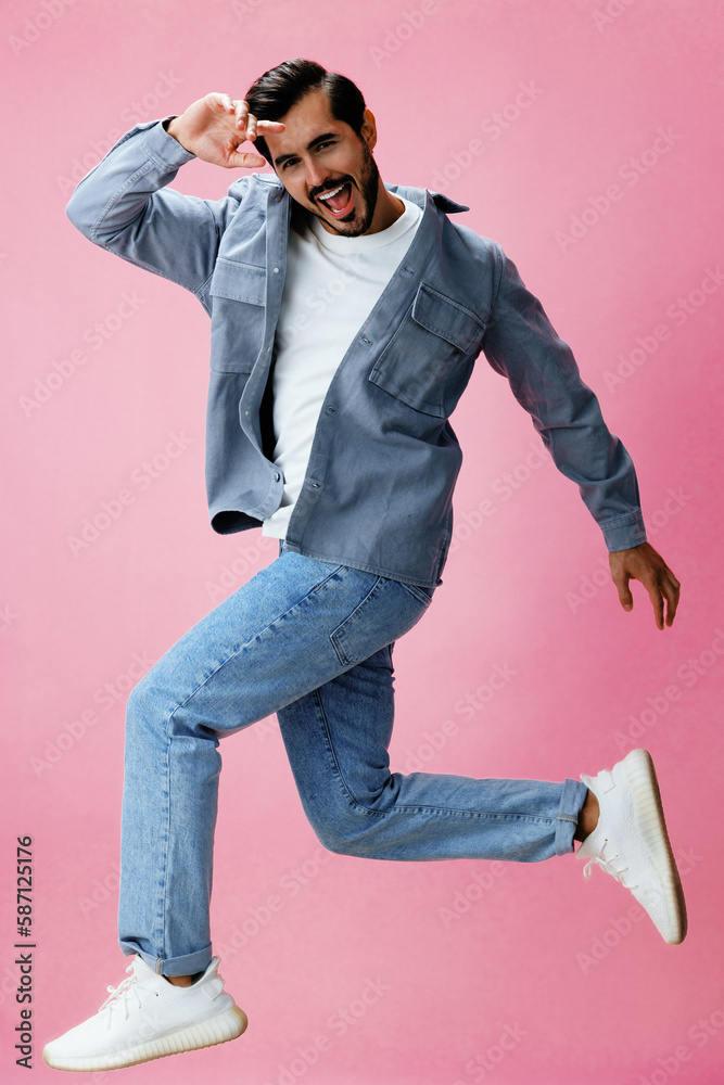 Fashion man with beard jumping on pink background in white t-shirt and jeans, smile and joyful emotion on his face, full-length, copy space Fashion man with beard jumping on pink background in white t-shirt and jeans, smile and joyful emotion on his face, full-length, copy space