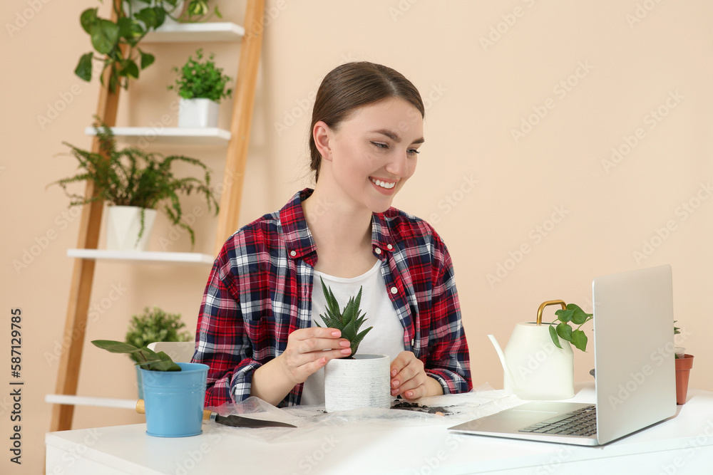 Woman taking care of plant following online gardening course at home. Time for hobby Woman taking care of plant following online gardening course at home. Time for hobby