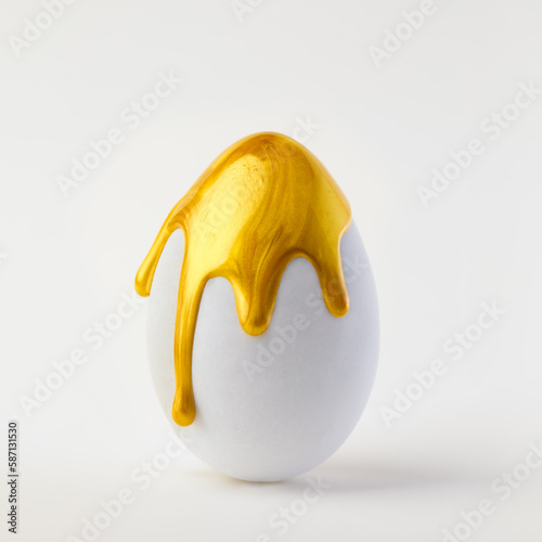 Konstfotografi Single white egg spattered and dripping with shiny golden paint