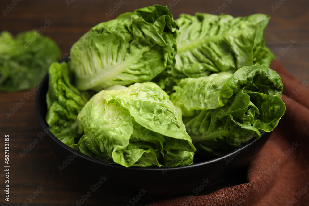 Bowl of fresh green romaine lettuces on wooden table, closeup Bowl of fresh green romaine lettuces on wooden table, closeup