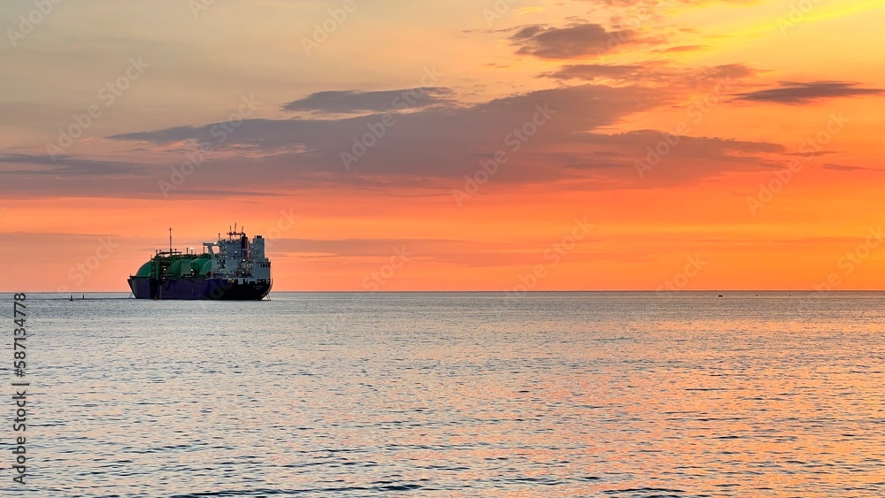 beautiful sunset with ship to the horizon. golden hour at sea
