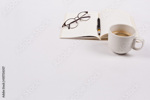 There are coffee cups, pens, books, and glasses
