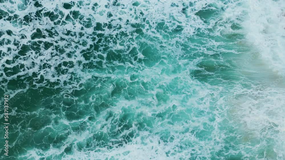 Blue sea water crashing of sandy beach in slow motion. Aerial view ocean waves. Blue sea water crashing of sandy beach in slow motion. Aerial view ocean waves.