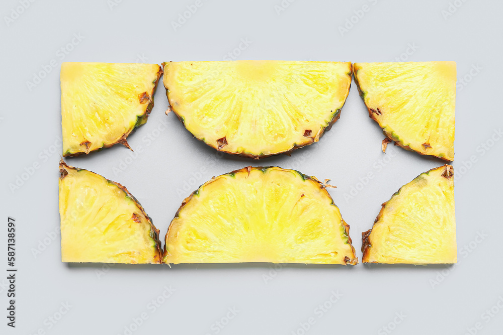 Slices of fresh ripe pineapple on grey background