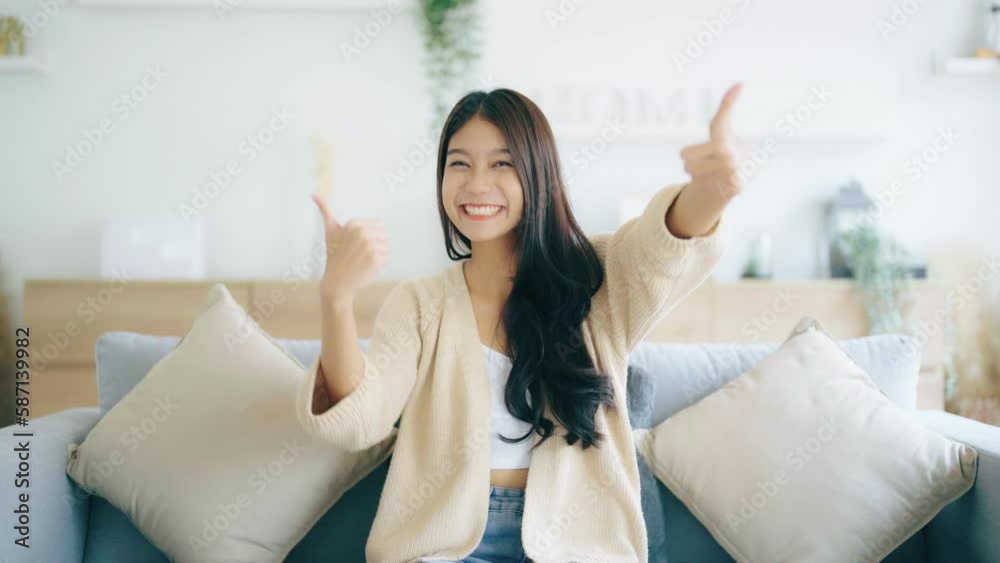 Happy teen asian girl blogger smiling face waving hand talking to webcam recording vlog, social media influencer streaming, making video call at home. She thumb up good or better Happy teen asian girl blogger smiling face waving hand talking to webcam recording vlog, social media influencer streaming, making video call at home. She thumb up good or better