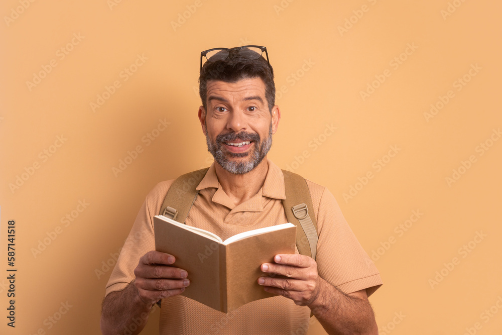 surprised older student holding academy book and smiling in studio shot. going to school, education, student concept. surprised older student holding academy book and smiling in studio shot. going to school, education, student concept.