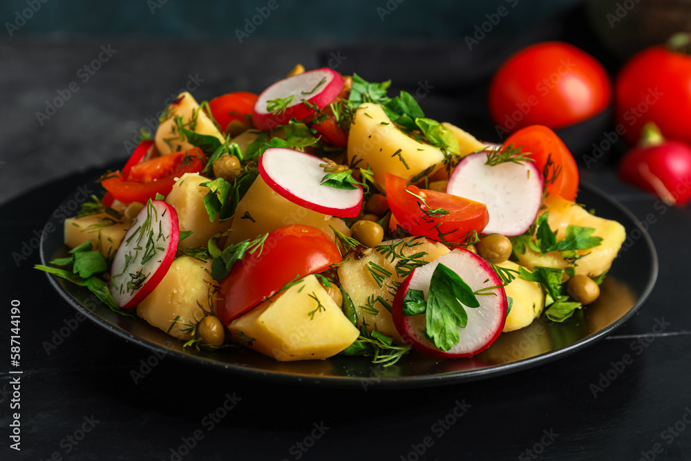 Plate of tasty Potato Salad with vegetables on dark background, closeup
