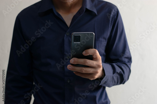 Man playing on mobile phone in house typing text messages chatting online