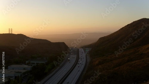 Aerial Shot Of Cars Moving On Roads Amidst Mountains, Drone Flying Forward During Sunset - Camarillo, California photo