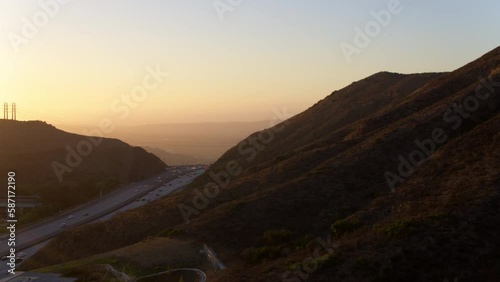 Aerial Panning Shot Of Cars Moving On Roads Amidst Mountains Against Clear Sky During Sunset - Camarillo, California photo