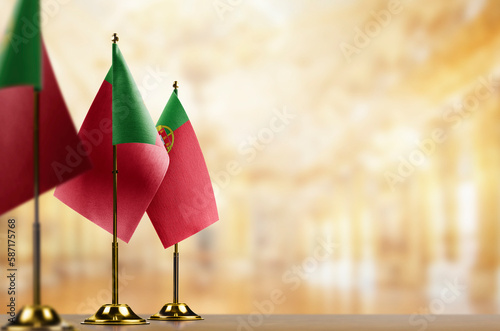 Small flags of the Portugal on an abstract blurry background