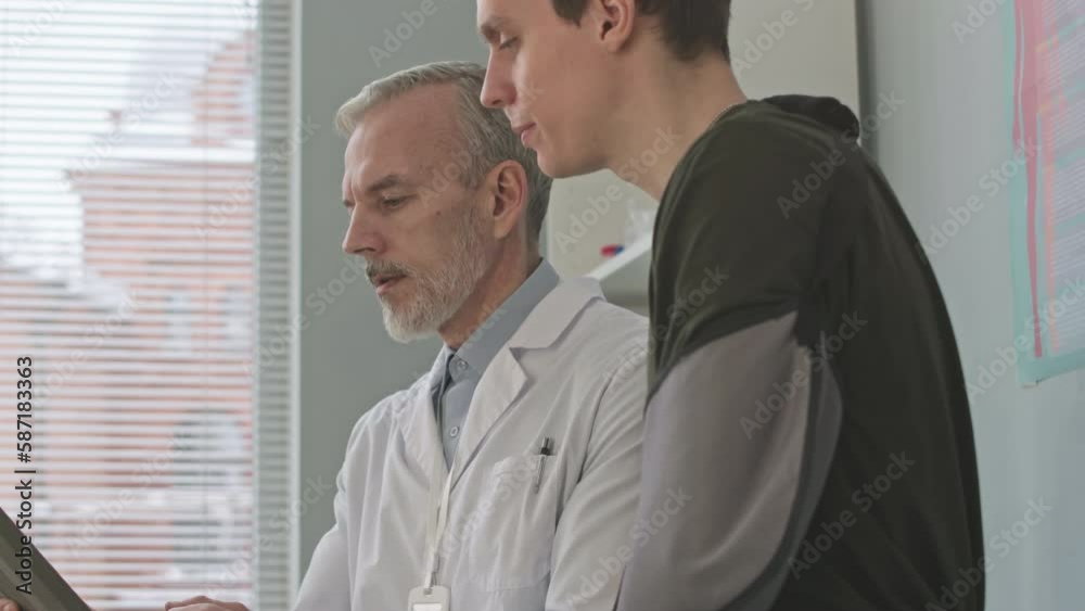 Young Caucasian army officer with broken arm having medical appointment at doctor office Young Caucasian army officer with broken arm having medical appointment at doctor office