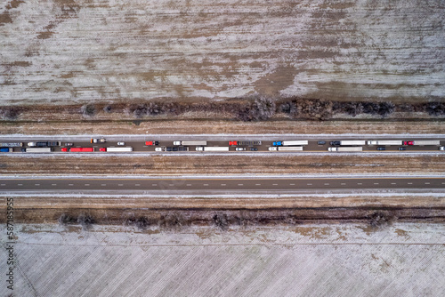 Aerial view of highway in Oklahoma after snow storm with traffic. Trucks and cars are going on interstate along fields.