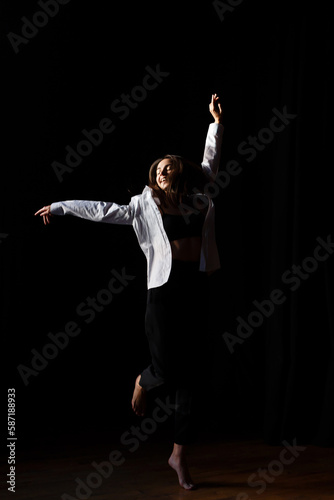 brunette actress dances barefoot in the rehearsal hall of the theater