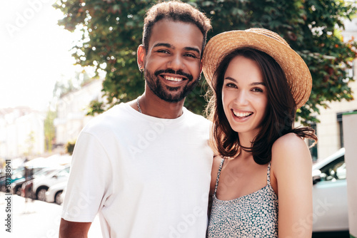 Smiling beautiful woman and her handsome boyfriend. Woman in casual summer clothes. Happy cheerful family. Female having fun. Sexy couple posing in the street at sunny day. In hat