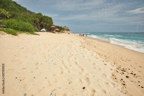 The idyllic Nyang Nyang beach in Uluwatu on Bali in Indonesia, with trees along the beach.