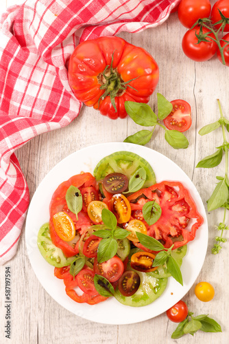 Healthy tomatoes salad with sauce and basil