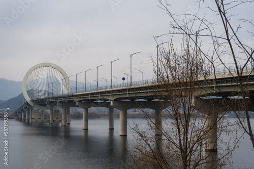 Chuncheon bridge over Soyang river with mountain and city view during winter afternoon at Chuncheon , South Korea : 11 February 2023