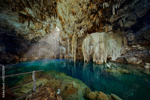 Cenote Dzitnup Xkeken, cave south of Valladolid. Landscape in Yucatán, Mexico. Green blue water lake in cave, light in the hole. Travel in Mexico. © ondrejprosicky