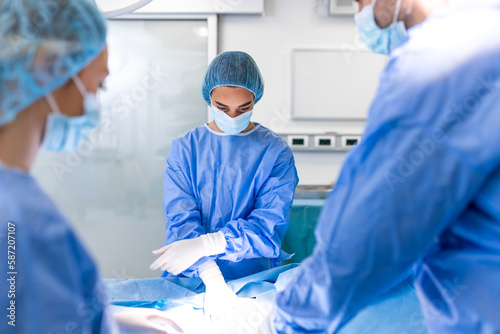 Team of Professional surgeon  Assistants and Nurses Performing Invasive Surgery on a Patient in the Hospital Operating Room. Surgeons Talk and Use Instruments. Real Modern Hospital.