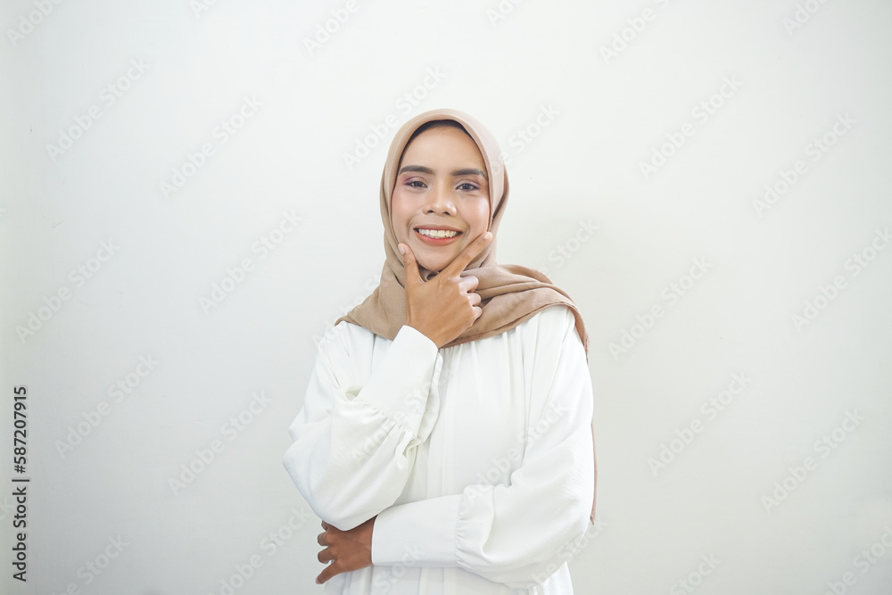 Smiling young Asian Muslim woman feels confident and joyful isolated over white background Smiling young Asian Muslim woman feels confident and joyful isolated over white background