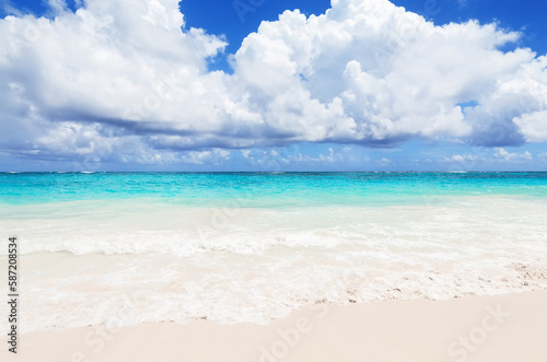 Fototapeta Naklejka Na Ścianę i Meble -  Landscape view of beautiful tropical white sand beach and turquoise sea in sunny day in Punta Cana, Dominican Republic.