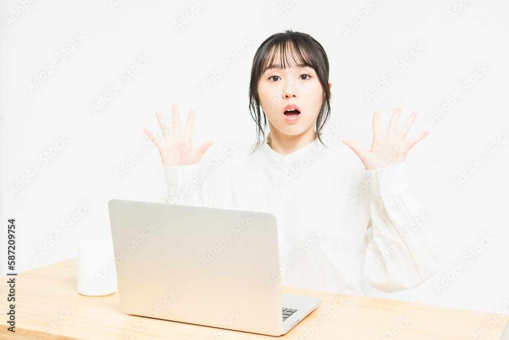 PCを使いながら驚いている若い女性 PCを使いながら驚いている若い女性