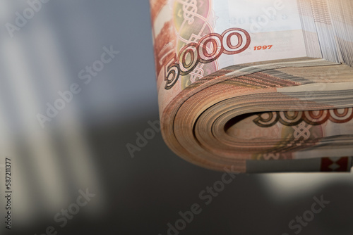 Russian money rubles. Five thousandth banknotes cash. A stack of money in a female hand with a French manicure. photo
