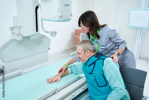 Doctor standing and helping patient to making x-ray at radiology room