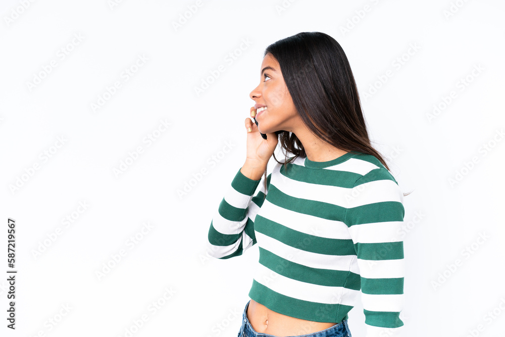 Young African American woman isolated on white background keeping a conversation with the mobile phone with someone Young African American woman isolated on white background keeping a conversation with the mobile phone with someone