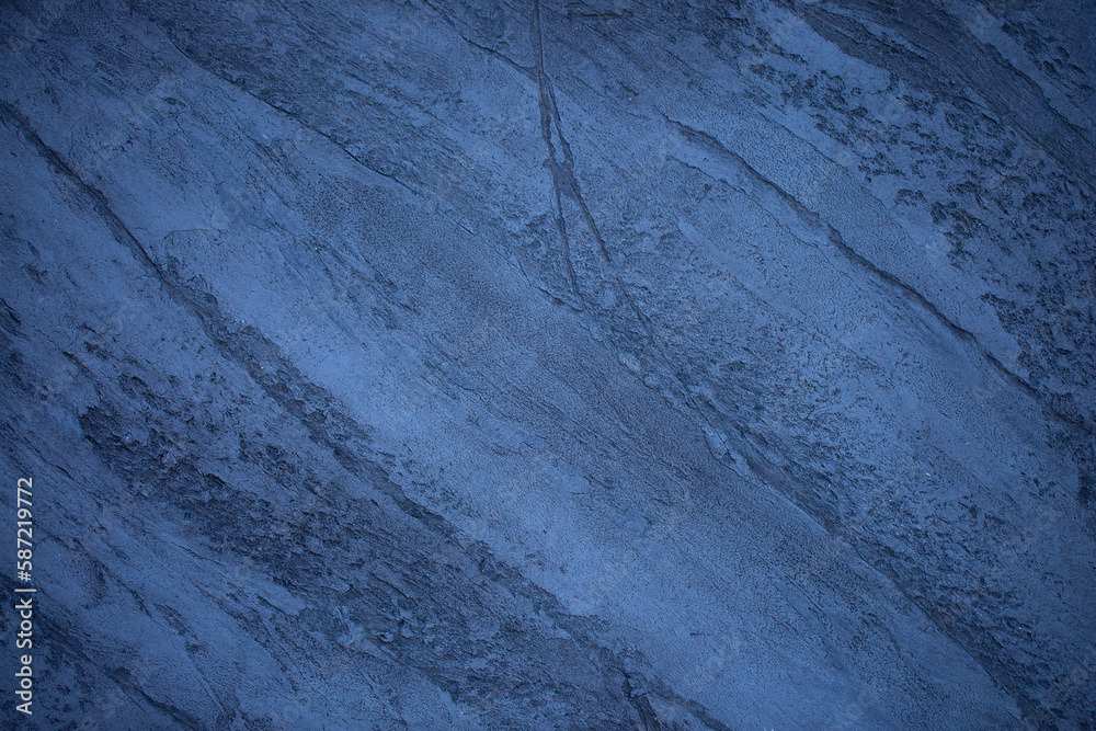 Fototapeta premium Blue background of decorative plaster with abstract spots. Unusual texture of this wall with beautiful patterns, creative surface background. Finishing coating for building cladding.