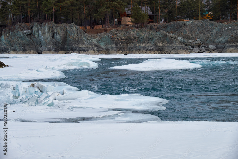 Rapids of Altai river Katun with banks covered by ice and snow in winter season near Elekmonar settlement.