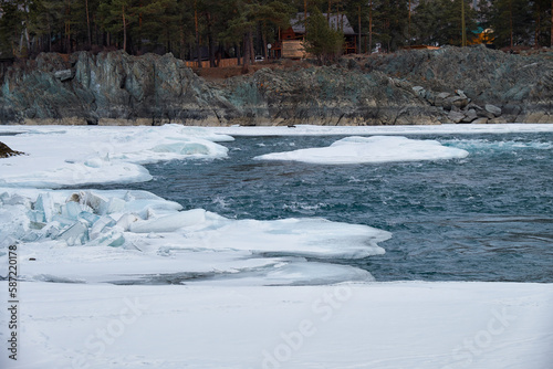 Rapids of Altai river Katun with banks covered by ice and snow in winter season near Elekmonar settlement.