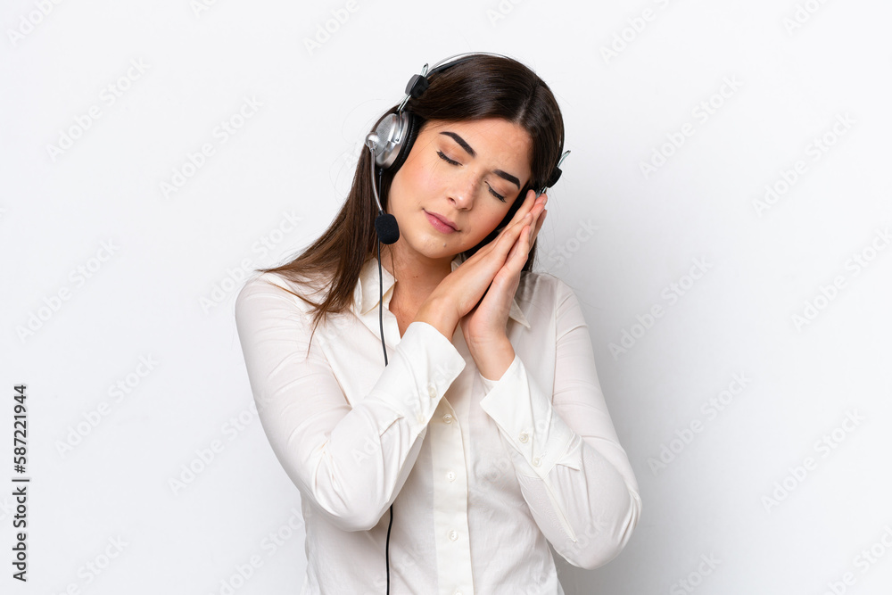 Telemarketer caucasian woman working with a headset isolated on white background making sleep gesture in dorable expression Telemarketer caucasian woman working with a headset isolated on white background making sleep gesture in dorable expression